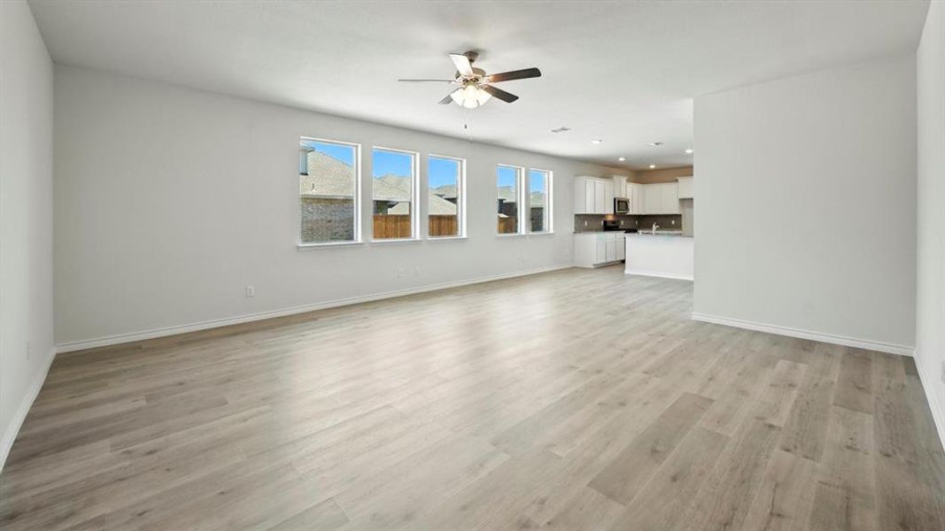 Unfurnished living room featuring light wood-style floors and ceiling fan