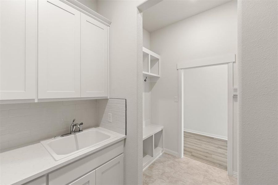 Mudroom with a sink and baseboards