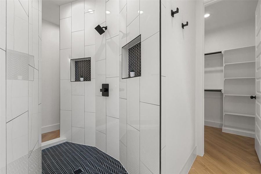 Full bathroom featuring a tile shower and light wood finished floors