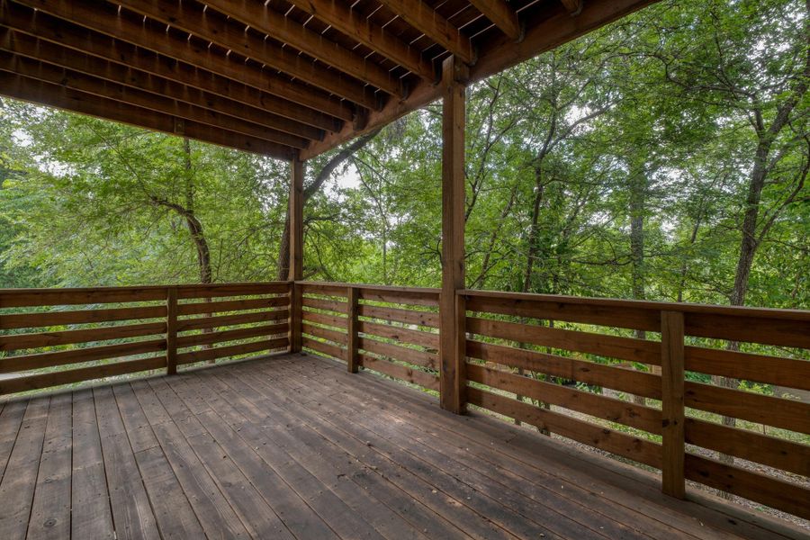 An inviting deck extends into a lush, tree-filled landscape, creating a private outdoor retreat. An inviting deck extends into a lush, tree-filled landscape, creating a private outdoor retreat.
