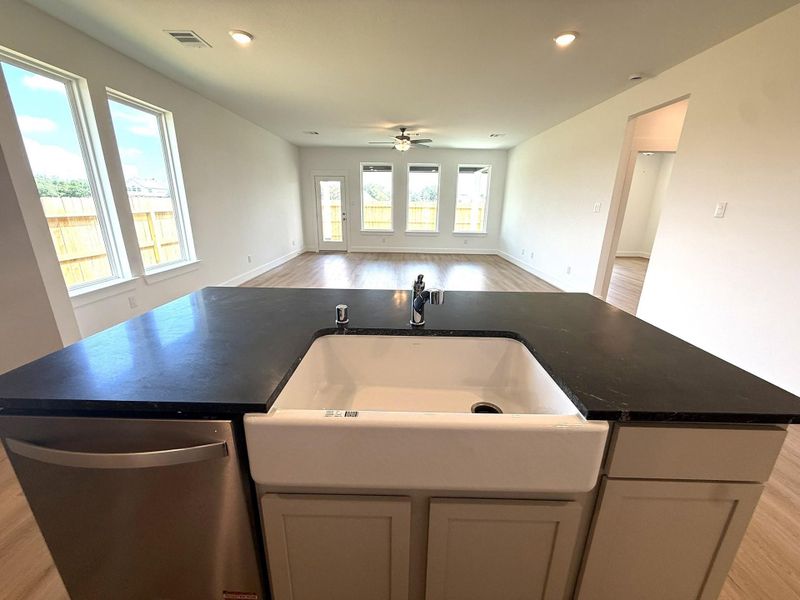 At the center of this showstopper sits a spacious oversized island, offering ample seating and workspace while providing a perfect vantage point to the family room and dining area.