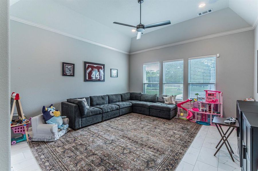 Living room featuring ceiling fan, vaulted ceiling, light marble finish flooring, recessed lighting, and ornamental molding Living room featuring ceiling fan, vaulted ceiling, light marble finish flooring, recessed lighting, and ornamental molding