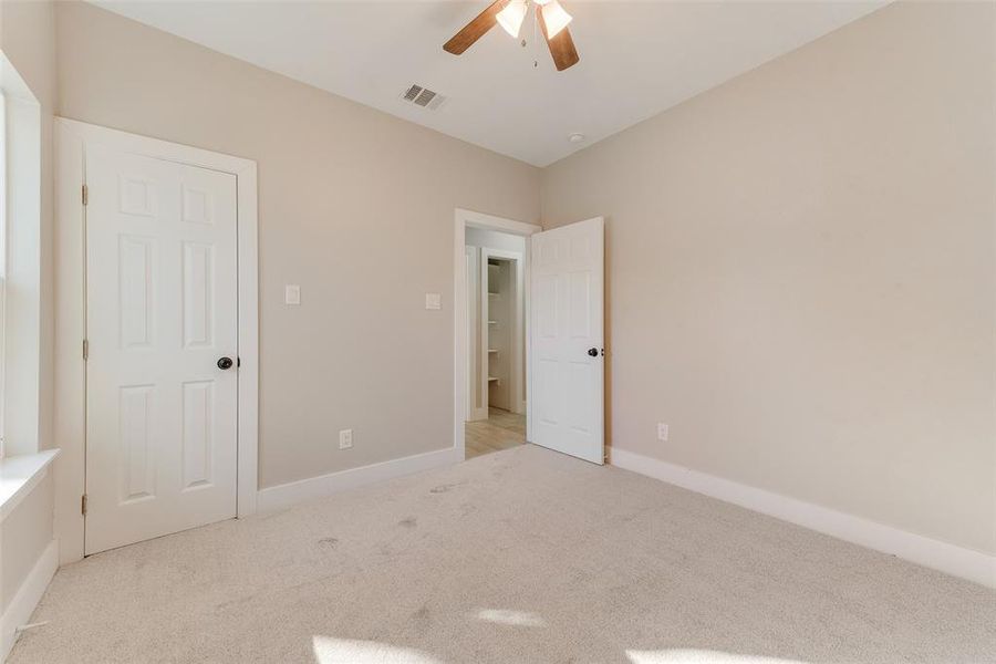 Unfurnished bedroom featuring light carpet and ceiling fan