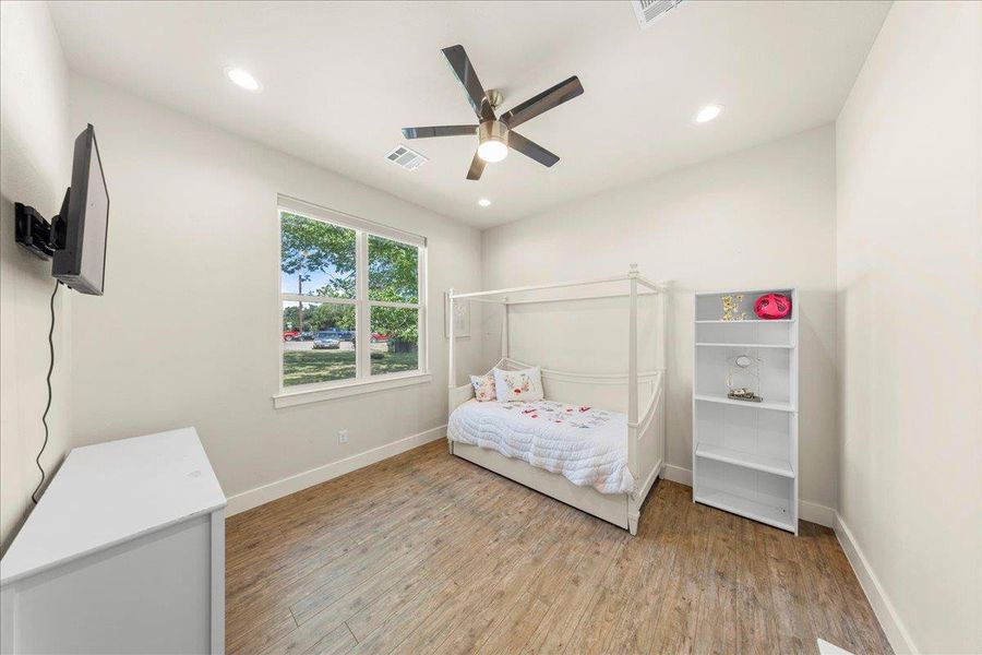 Bedroom with light wood-type flooring, recessed lighting, and a ceiling fan Bedroom with light wood-type flooring, recessed lighting, and a ceiling fan