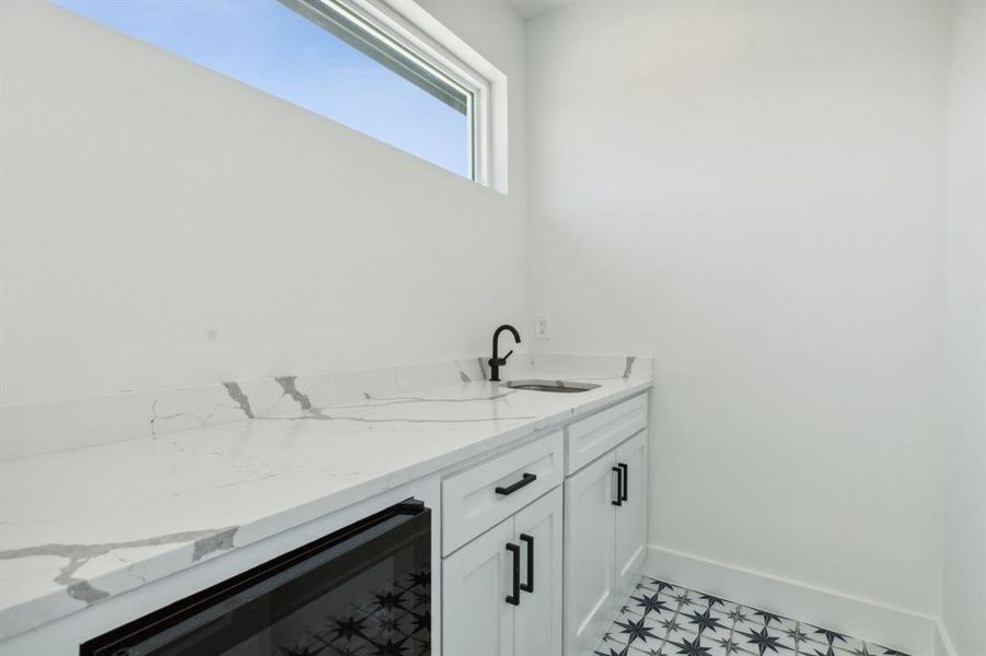 Wet bar featuring sink and wine fridge