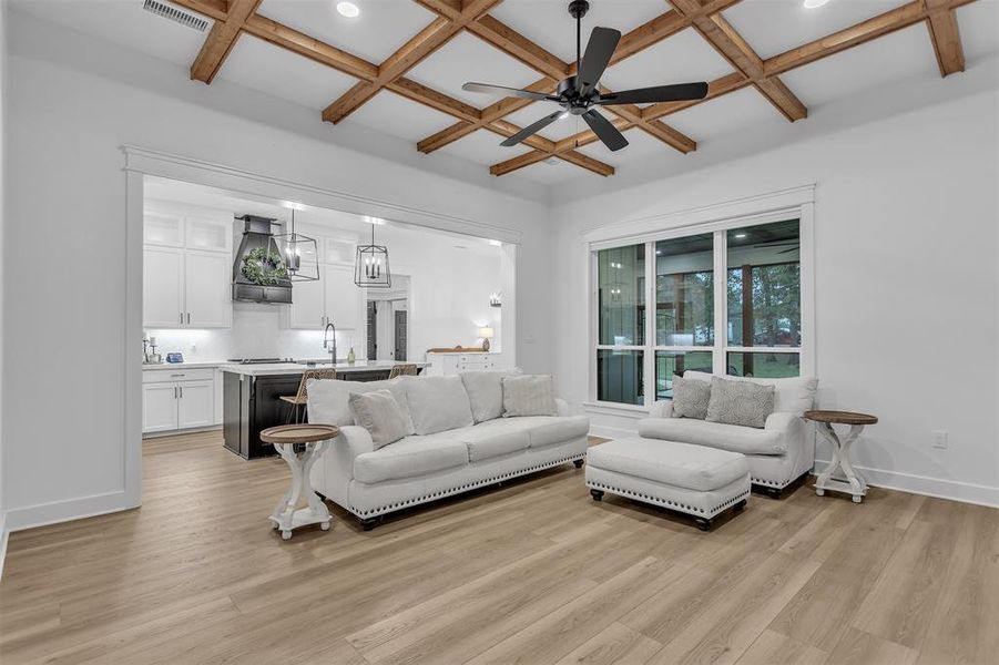Living room featuring coffered ceiling, a ceiling fan, light wood finished floors, beam ceiling, and recessed lighting Living room featuring coffered ceiling, a ceiling fan, light wood finished floors, beam ceiling, and recessed lighting