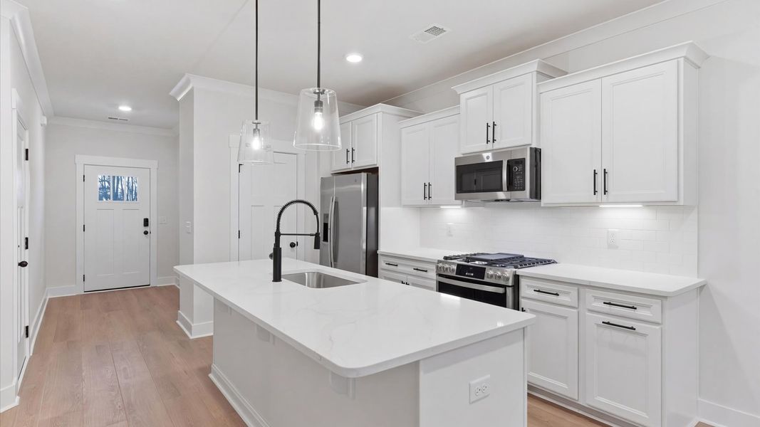 Elegant and compact island anchors this tasteful kitchen with high standards and timeless appeal at Pelham Crossing