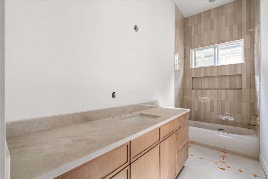 Bath 2 serves the flex space and is attached to bedroom 2. Beautiful white oak cabinets and Taj Mahal counters included in all the bathrooms.