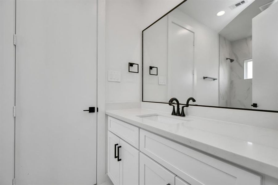 Indulge in the luxury and convenience of the Jack and Jill bathroom adjoining both guest bedrooms featuring generous vanity, ample space for your toiletries and personal essentials