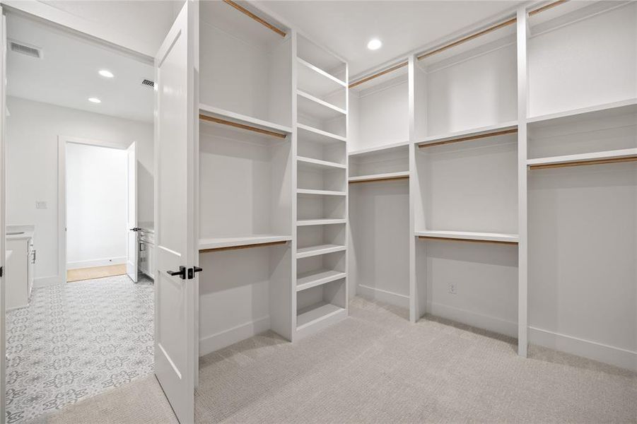Walk in closet featuring light carpet Walk in closet featuring light carpet