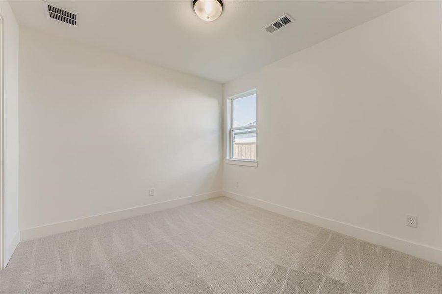 Carpeted empty room featuring baseboards
