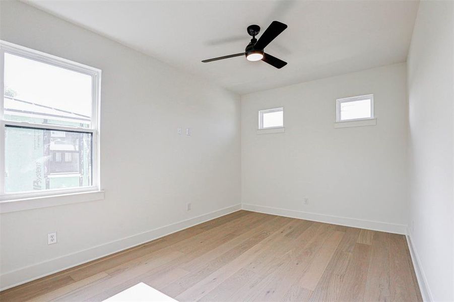 Unfurnished room with a healthy amount of sunlight, ceiling fan, and light wood-type flooring