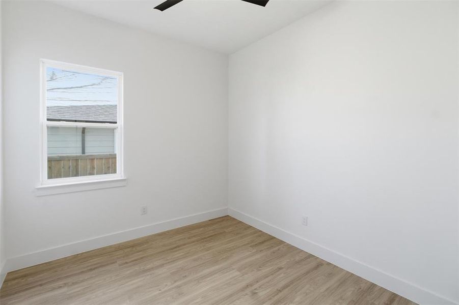 Spare room with light wood finished floors and a ceiling fan