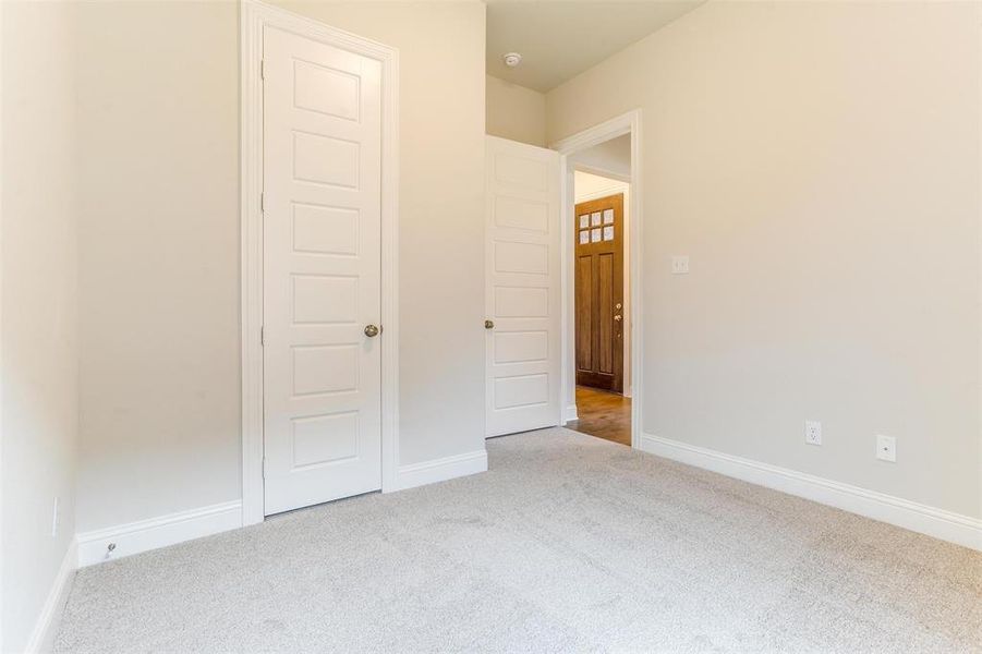 Unfurnished bedroom featuring light colored carpet