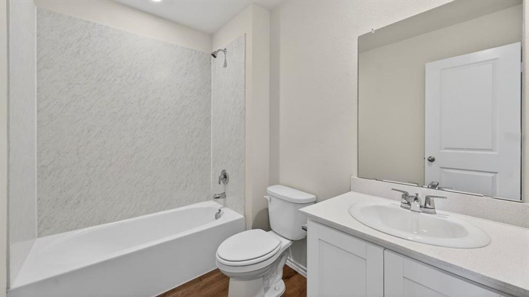 White vanity with a single basin sink, chrome faucet, and expansive wall mirror