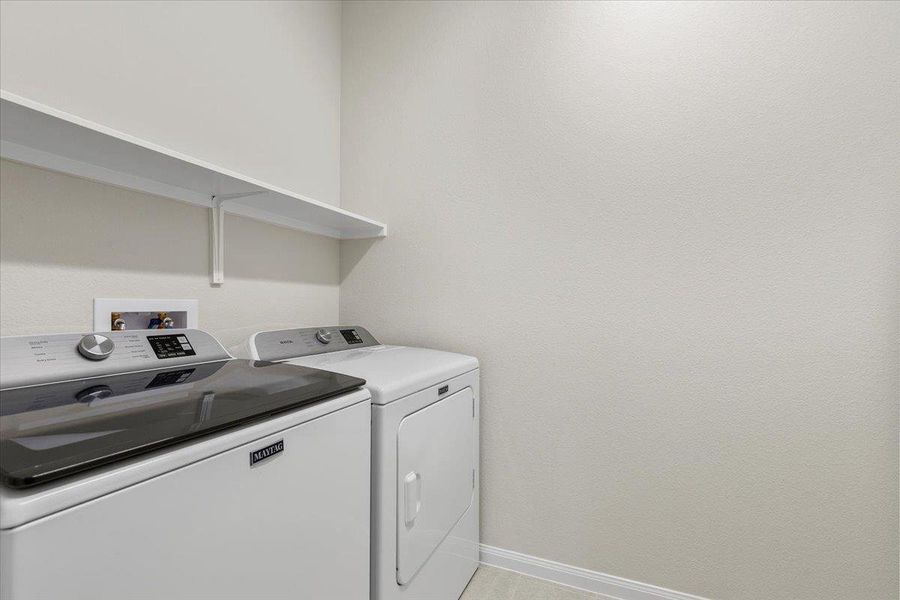 Laundry Room - tucked behind the kitchen with a shelf to store your laundry essentials.