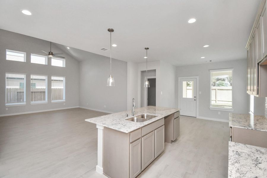 All of this overlooks your expansive family room, creating a perfect space for culinary delights and family gatherings. Sample photo of completed home with similar floor plan. Actual colors and selections may vary. All of this overlooks your expansive family room, creating a perfect space for culinary delights and family gatherings. Sample photo of completed home with similar floor plan. Actual colors and selections may vary.