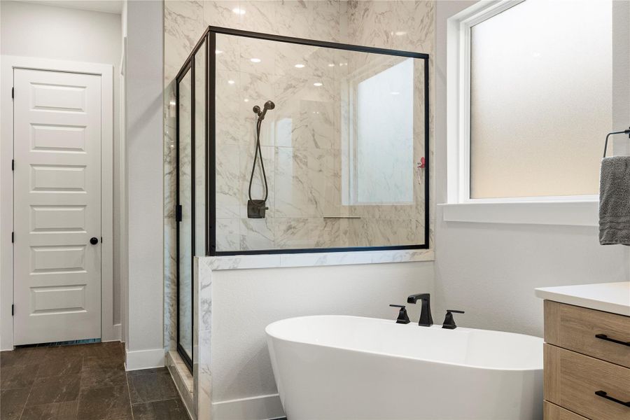 A refined bathroom featuring a sleek frameless glass shower and a contemporary freestanding soaking tub. A refined bathroom featuring a sleek frameless glass shower and a contemporary freestanding soaking tub.