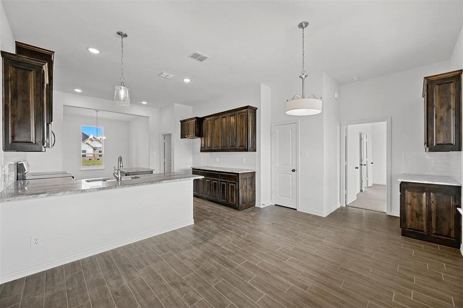 Kitchen featuring wood-type flooring, range, dark brown cabinets, and sink