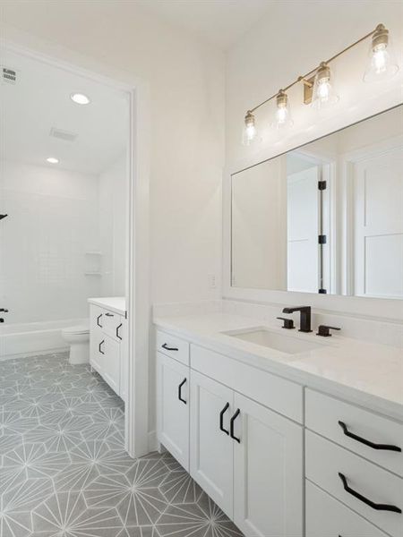 Bathroom featuring a double vanity with white cabinetry, quartz countertops, and matte black hardware Bathroom featuring a double vanity with white cabinetry, quartz countertops, and matte black hardware