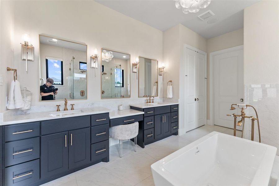 Natural light, vertical windows, and a freestanding tub give this bath a calm retreat-like feel. The upgraded tile and plumbing selections add the level of detail expected in a custom luxury home.