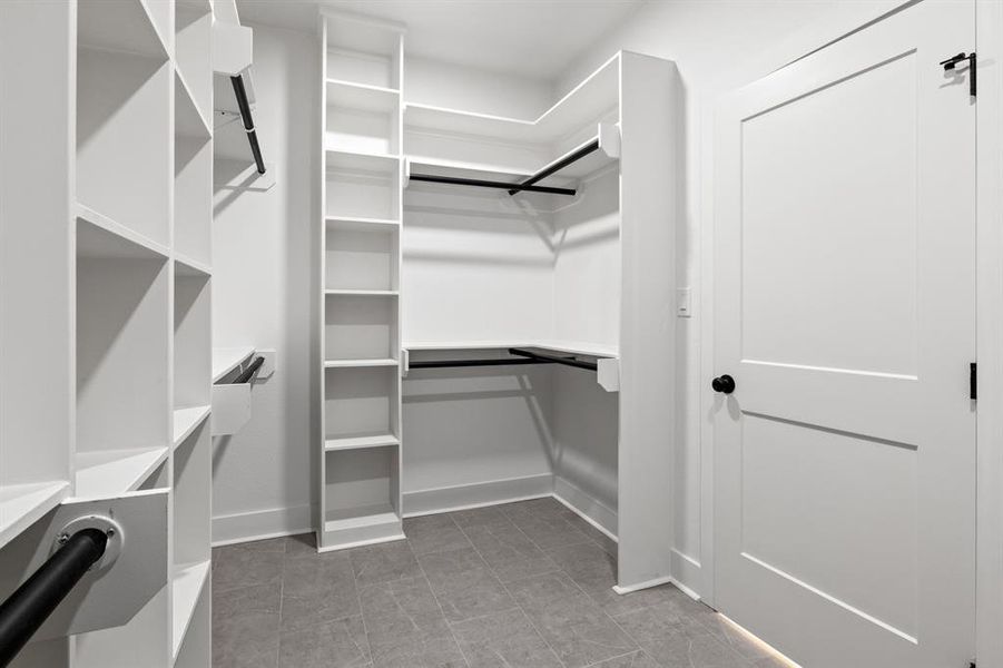 Walk in closet with light tile patterned floors