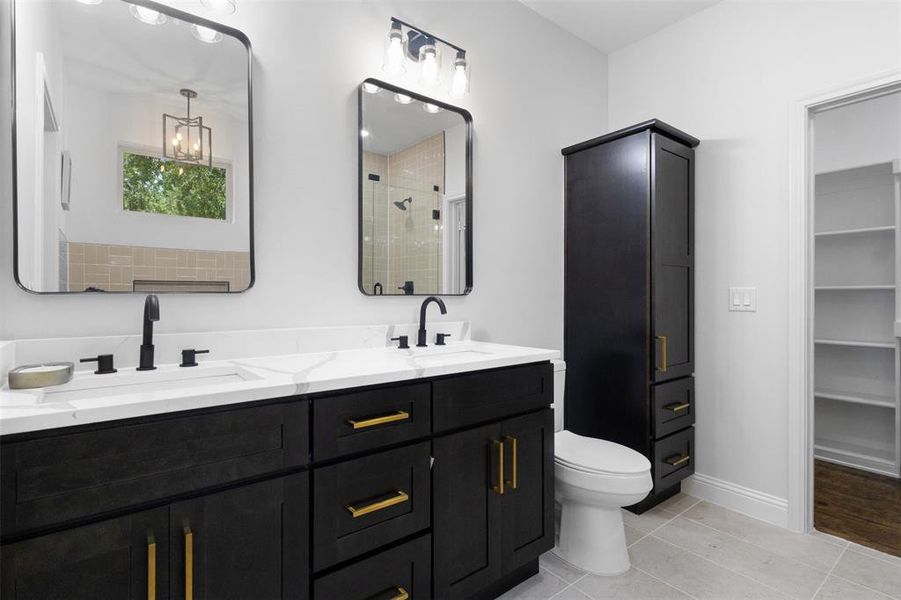 Full bathroom featuring a stall shower, double vanity, and tile patterned floors Full bathroom featuring a stall shower, double vanity, and tile patterned floors