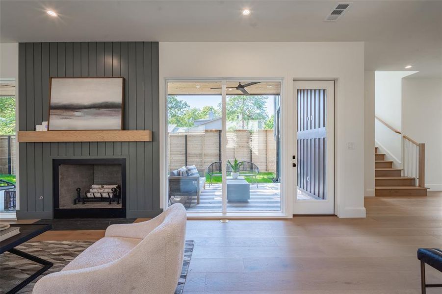 Living room with a large fireplace and hardwood / wood-style flooring