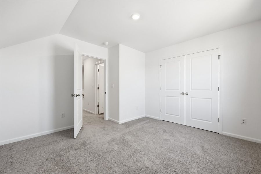 Unfurnished bedroom featuring light colored carpet and a closet Unfurnished bedroom featuring light colored carpet and a closet
