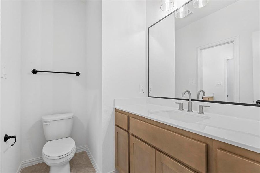 Bathroom featuring vanity, tile patterned floors, and toilet