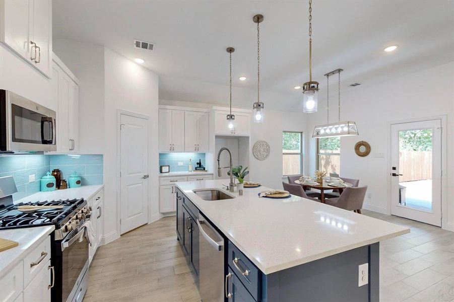 Kitchen with white cabinetry, backsplash, and appliances with stainless steel finishes