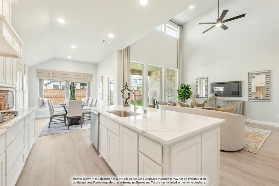 Open-concept kitchen with white island, quartz countertop, and vaulted ceiling overlooking dining and living areas with hardwood floors. Open-concept kitchen with white island, quartz countertop, and vaulted ceiling overlooking dining and living areas with hardwood floors.