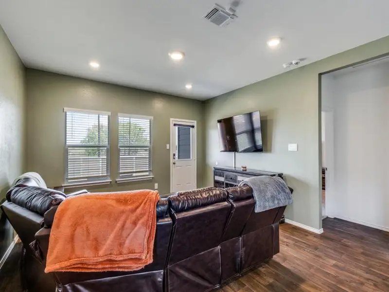 Living area featuring dark wood-style flooring and recessed lighting