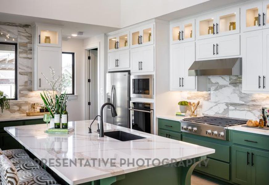 Kitchen featuring a sink, white cabinets, appliances with stainless steel finishes, under cabinet range hood, and green cabinets Kitchen featuring a sink, white cabinets, appliances with stainless steel finishes, under cabinet range hood, and green cabinets
