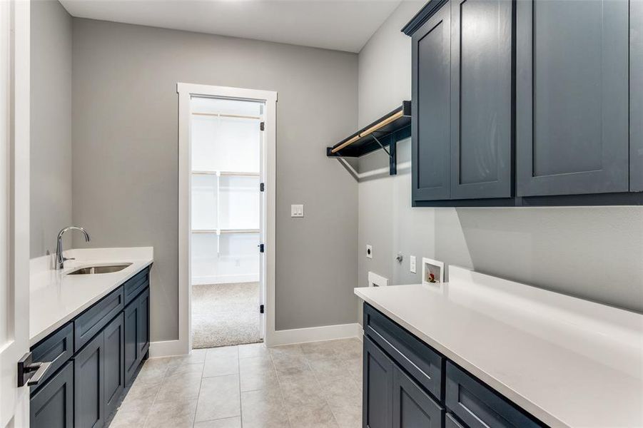 Laundry area featuring hookup for an electric dryer, hookup for a washing machine, cabinet space, and light tile patterned flooring Laundry area featuring hookup for an electric dryer, hookup for a washing machine, cabinet space, and light tile patterned flooring
