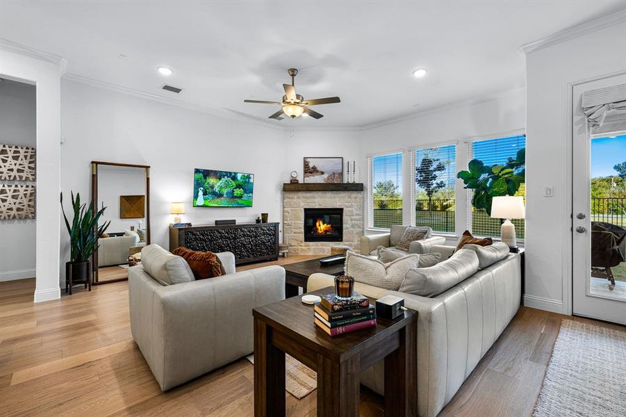 Living area with crown molding, a fireplace, a ceiling fan and recessed lighting Living area with crown molding, a fireplace, a ceiling fan and recessed lighting