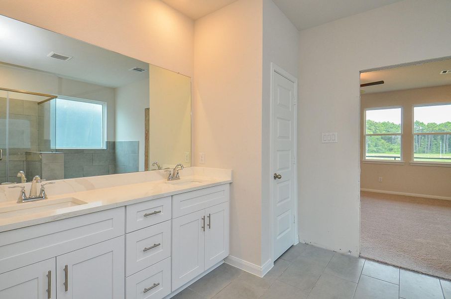 Notice the double sinks, and the white cabinetry that offers ample storage. Notice the double sinks, and the white cabinetry that offers ample storage.