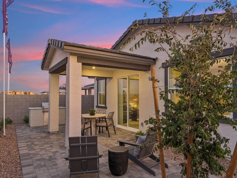 A house with a patio and a tree in the front.