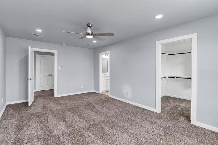 Unfurnished bedroom with carpet flooring, a walk in closet, recessed lighting, a ceiling fan, and ensuite bathroom