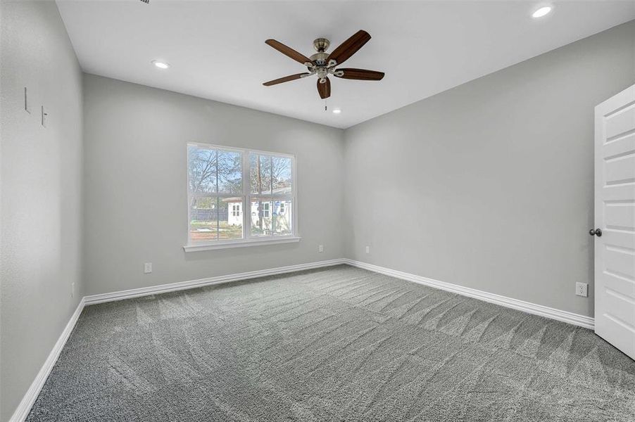 Carpeted empty room featuring ceiling fan