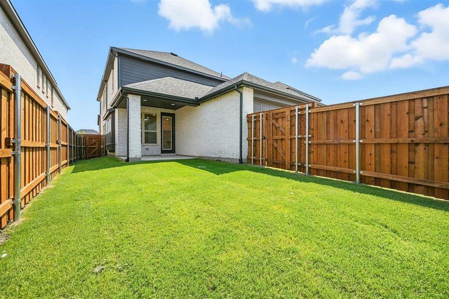 Rear view of house with a patio, a fenced backyard, brick siding, and roof with shingles Rear view of house with a patio, a fenced backyard, brick siding, and roof with shingles