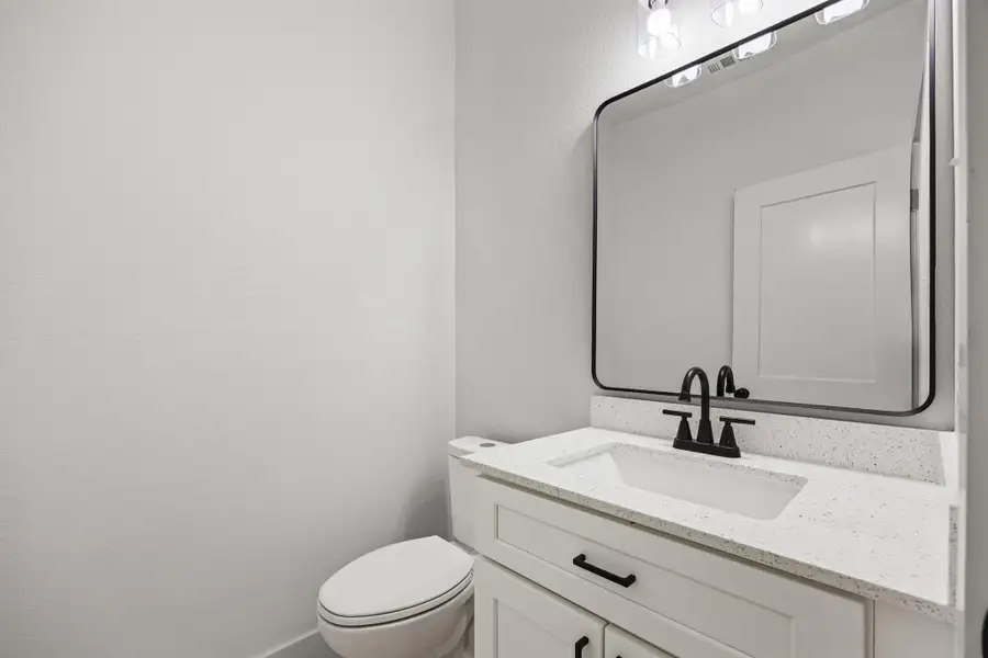 Half bathroom featuring vanity and toilet Half bathroom featuring vanity and toilet