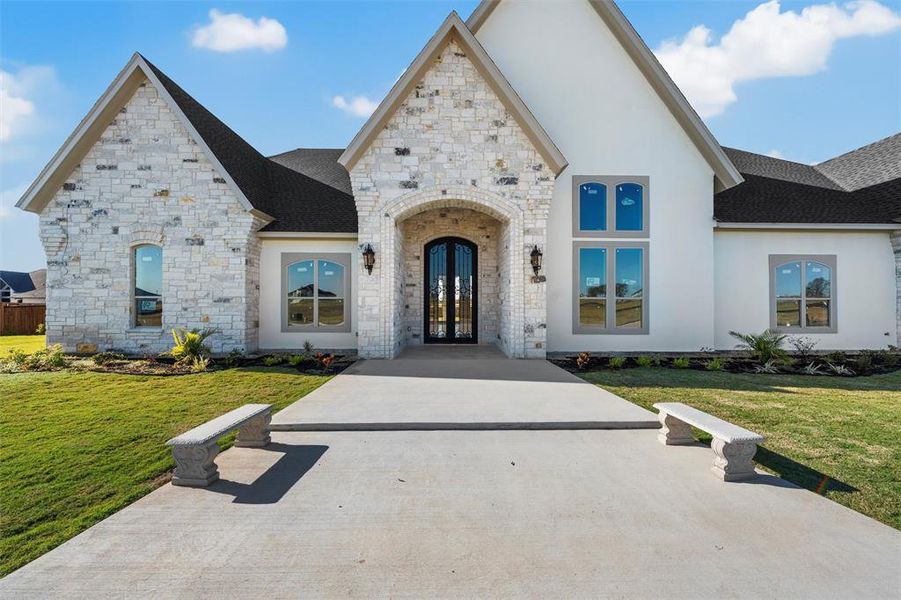 French country style house featuring a front yard, a shingled roof, french doors, and stucco siding French country style house featuring a front yard, a shingled roof, french doors, and stucco siding