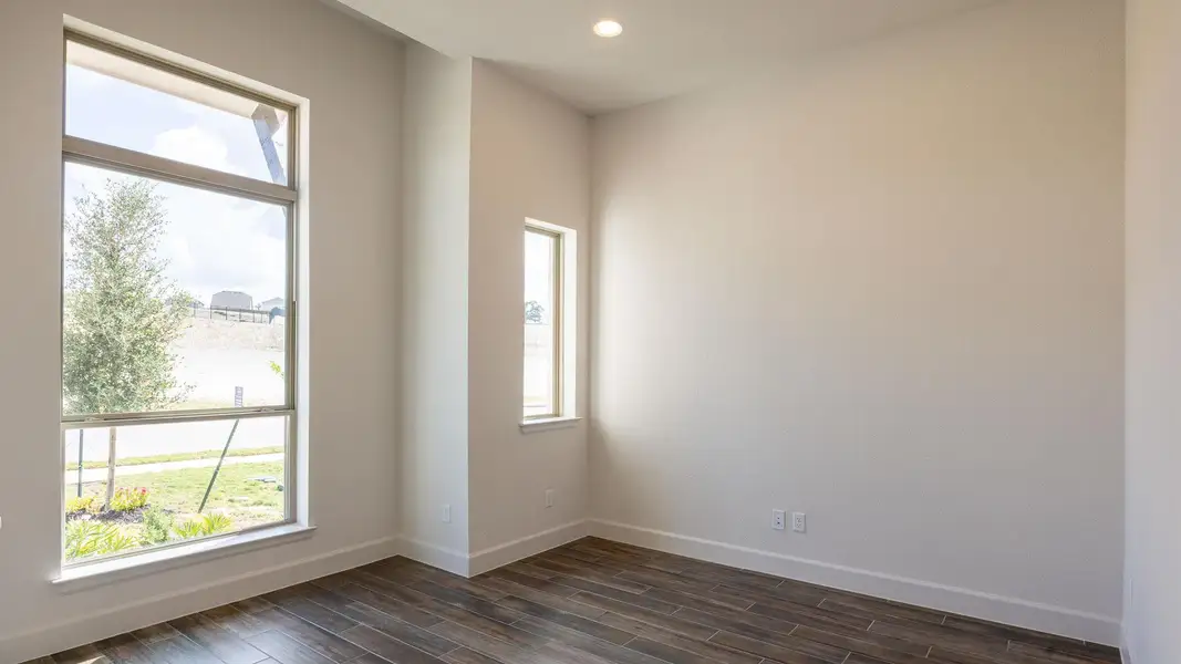 Spare room with plenty of natural light, wood finish floors, and recessed lighting Spare room with plenty of natural light, wood finish floors, and recessed lighting