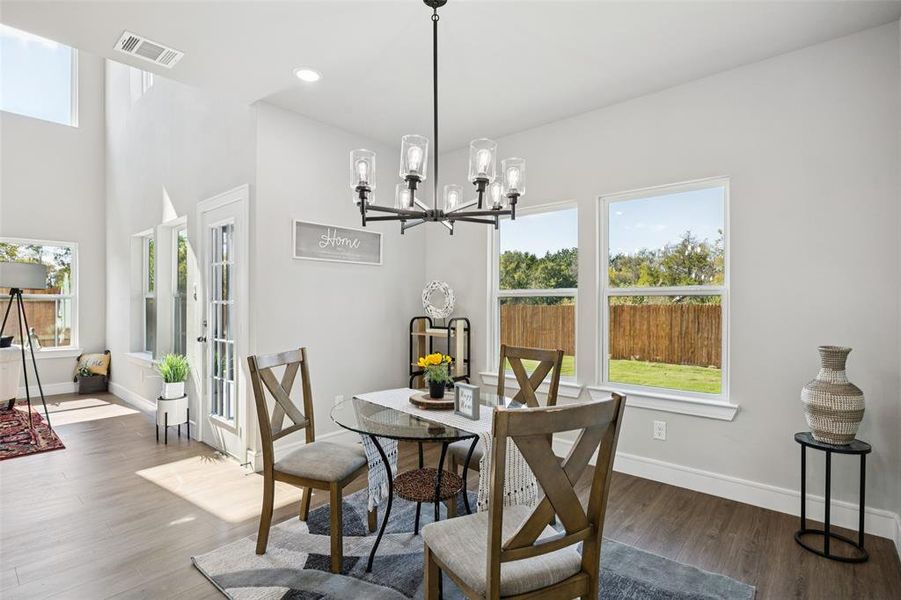 Dining room with dark wood-style floors, a chandelier, and recessed lighting