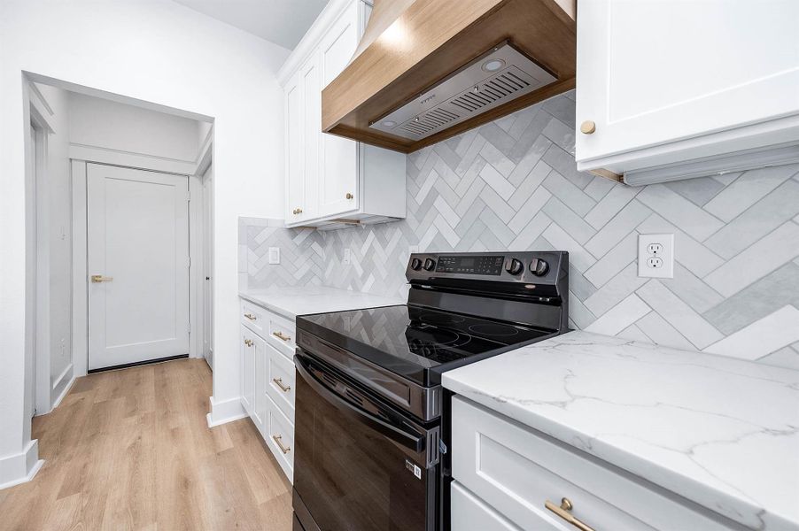 Side view highlighting the custom vent hood and herringbone backsplash detail.