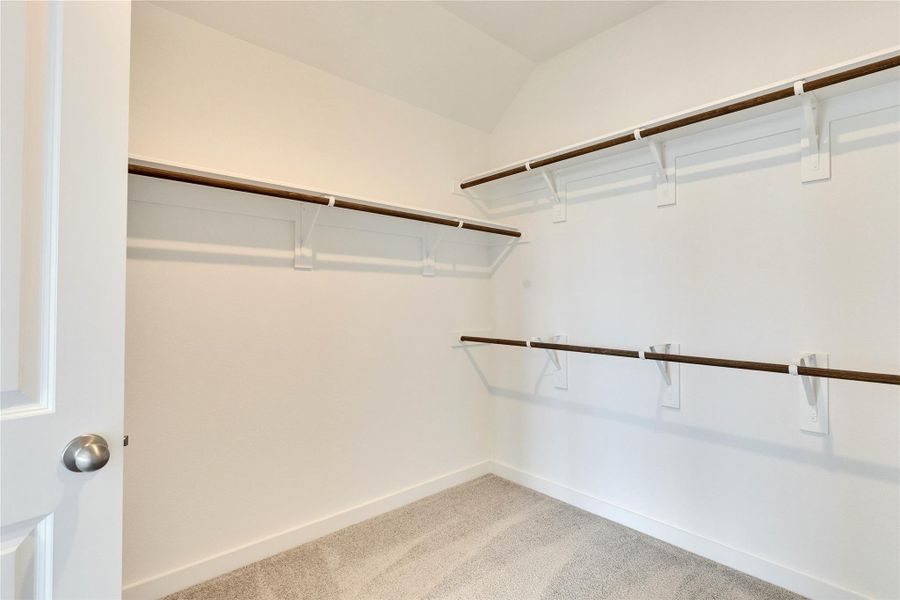 Spacious closet with light colored carpet Spacious closet with light colored carpet