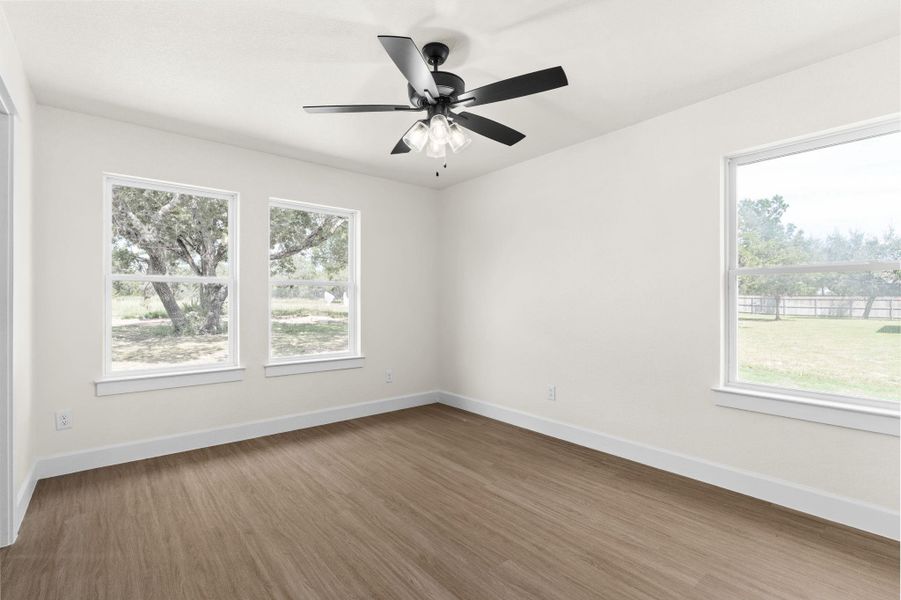 Spare room with light wood finished floors and a ceiling fan