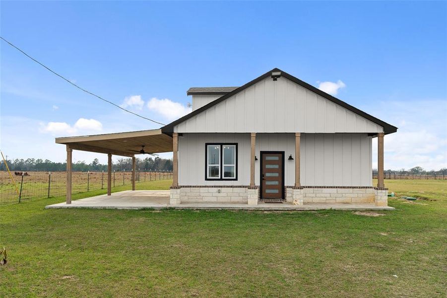 Rear view of house featuring covered porch, a view of countryside, and ceiling fan