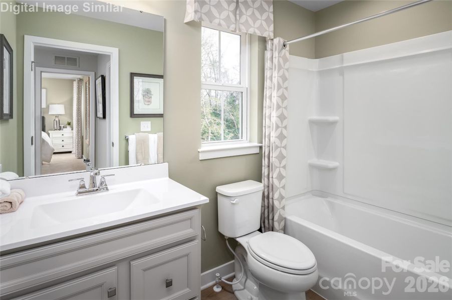 Sleek, spacious, and effortlessly stylish—this shared full bath on the upper level is a total showstopper. Natural light pours in through the window, illuminating clean lines and built-in shower shelves that blend form with function. It’s a polished retreat designed for comfort and ease.